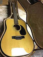 Full view of the natural finish 12 string acoustic Vanguard HGV-195 guitar inside the open plush-lined case