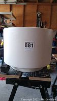 Front view of large cream white ceramic planter with auction lot sticker visible.