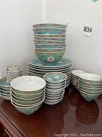 Stack of plates and bowls showing turquoise exterior with floral and character motifs