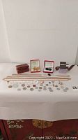 Assortment of necklaces, brooches, pendants, clip-on earrings, and coins displayed on table