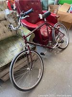 Maroon Schwinn Sierra city bike in an indoor setting with furniture around it.