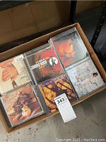 Box showing top view of multiple CDs with visible cover arts, including Luther Vandross and Tom Jobim albums.