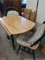 Drop leaf dining table with two matching chairs with floral cushions