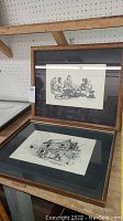 Two framed lithographs shown together, one depicting group of people and one depicting a building, black mats and wood frames