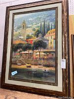 Full view of framed landscape print depicting a Mediterranean village scene with boats and trees in a multi-layered frame.