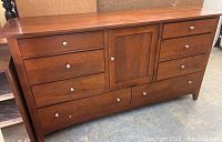 Front view of the Kincaid dresser showing six drawers and one cabinet door with metal knobs.