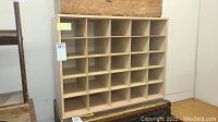 Front view of wooden storage unit showing 25 open cubby compartments in a 5x5 grid.