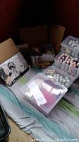 Wide view of multiple clipboards, plastic containers filled with paints, and yarn on a cloth background.