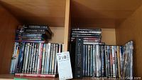 Full view of DVDs arranged on wooden shelves showing Game of Thrones black box set and assorted DVDs mainly movies and TV series including Supernatural.