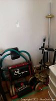 Photo showing AB Revolutionizer ab crunch machine, weights, dumbbells, and part of pull-up bar stand
