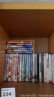 Photo of DVD shelf, multiple DVDs arranged showing various movie titles including kids movies and TV series