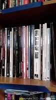 Shelf view of music books mostly showing spines of titles such as 'The Very Best of Prince', 'Metallica Under the Microscope', and 'Big Slab of Tab'.