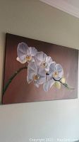 Front view of the signed oil painting featuring white orchids on a brown background.