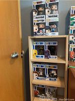 Ten Funko Pop! boxed vinyl figures displayed on shelving and against a door. Includes Stranger Things characters, Star Wars characters, and NHL player figures.