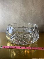 Side view of one large crystal bowl with measuring tape showing approx. 8 inch diameter.