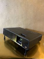 Front side view of the black ViewSonic PJ359W digital projector showing lens and vented panel.