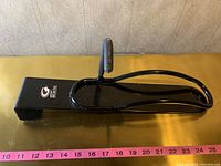 Photo of the black metal bicycle storage rack showing the side profile with hook and curved support.