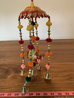 Full length view of the Indian hanging elephant decoration showing colorful pom-poms, beads, bells, and painted elephant.
