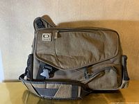 Front view of the OGIO messenger bag showing zippered compartments and padded shoulder strap