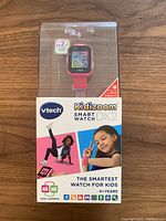Front view of boxed pink VTech Kidizoom Smart Watch DX2 showing front of packaging with watch display and branding