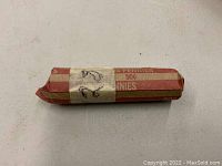 Single photo showing a rolled coin paper wrap, striped red and beige, labeled for 50 cents in pennies, noted as unsearched 1928 wheat pennies.