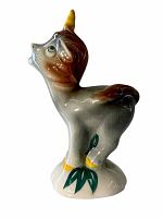 Side profile of the ceramic Baby Unicorn figurine showing color gradient from brown to cream with yellow horn and hooves and green leaves at the base.