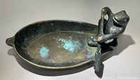 Top view of bronze frog sitting in the rowboat showing the interior and verdigris spots