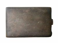 Top view of antique sterling silver smoker's case showing textured guilloche finish and side push-button clasp.