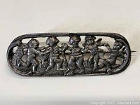 Front view of antique sterling silver bar pin featuring openwork cherub design.