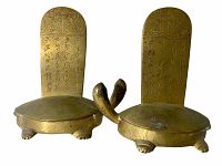 Front view of the pair of brass or bronze Korean turtle-shaped bookends showing engraved backs and facing heads.