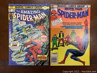 Photo showing both comic covers: The Amazing Spider-Man #143 on the left with Cyclone on cover, Marvel Tales Spider-Man #147 on right with The Enforcers and Spider-Man illustrated.