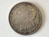 Obverse side of 1921 Morgan Silver Dollar coin showing Lady Liberty profile, inscriptions, and date.