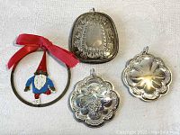 Four Towle ornaments, one gnome in silverplate with red bow, three sterling silver with floral and Liberty Bell motifs