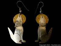 Front view of the pair of Native American style howling wolf earrings, showing silver wolf shapes in front of gold-toned circular backgrounds etched with star patterns.