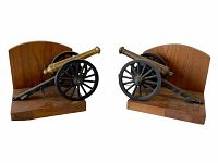 Pair of vintage bookends with solid wood bases and cast metal canon replicas, 5 inches tall each.