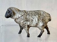 Side view of cast iron sheep bank showing shape and paint wear