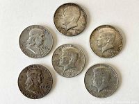 Obverse side of six silver half dollars showing profiles of Kennedy and Franklin with visible years 1959, 1961.