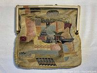 Full front view of the Art Deco woven purse with metal frame and clasp, showing worn fabric and multi-color bird motif tapestry.