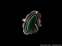 Top-down view of the ring showing the marquise green turquoise stone surrounded by twisted silver wire and floral and leaf accents on a black background.