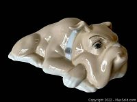 Side angled view of a vintage porcelain bulldog figurine with a blue spiked collar, showing glaze and detail.