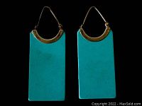 Pair of turquoise slab and sterling silver earrings shown against black background