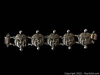 Front view of vintage sterling silver bracelet with five Kabuki mask face panels linked together and attached clasp.