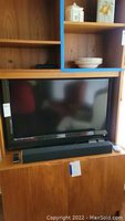 Photo showing the Vizio flat screen TV set up in a wooden cabinet
