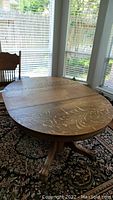 Photo of the oak breakfast table showing the round top with carved details.