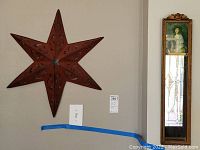 Wide view showing red tin Texas star and tall antique mirror with painted portrait panel above mirror section