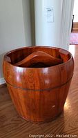 Front view of the antique wooden bucket with interior wooden piece visible.