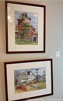 Two framed and matted watercolor paintings hanging on a wall, showing overall lot.