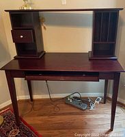 Full view of wood desk and hutch showing side drawer, cubbies, vertical slots, and pull-out keyboard tray