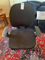 Front view of the black mesh desk chair showing padded seat and backrest with armrests.