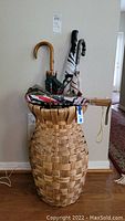 Full view of hourglass wicker basket holding six umbrellas